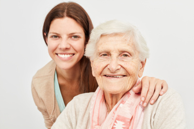 young caregiver together with happy elderly woman