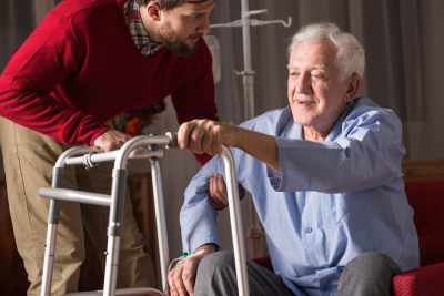 man helping senior man to stand