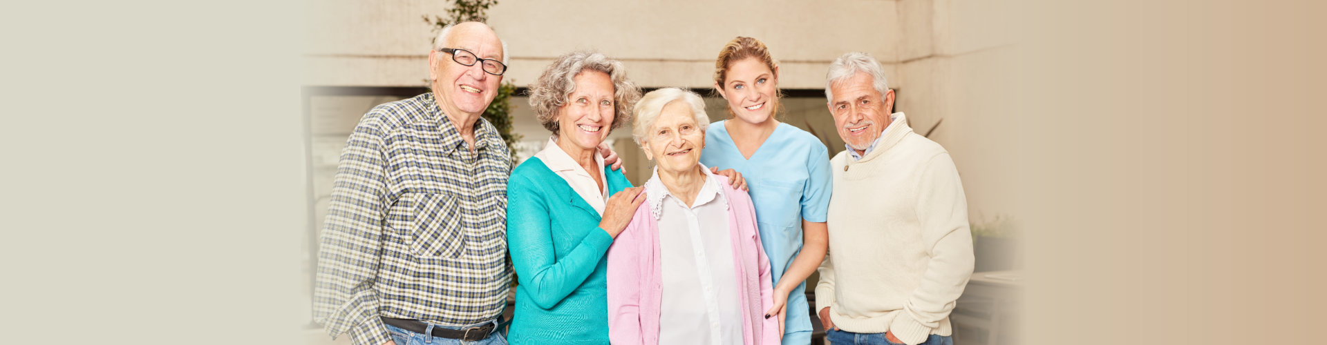 group of elderly people and a caregiver smiling