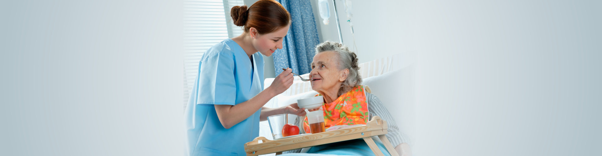 caregiver preparing medicine to an elderly woman